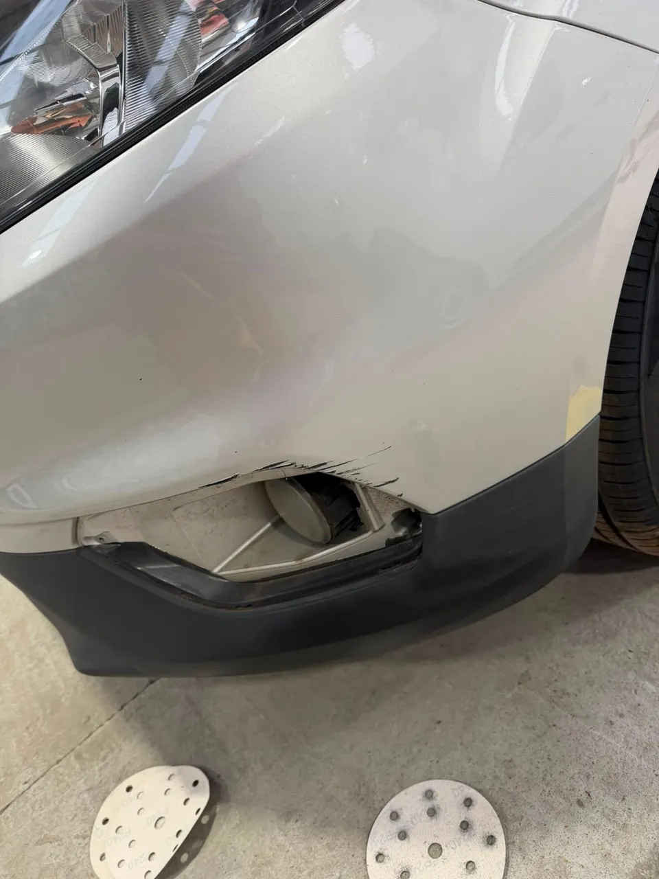 Front bumper corner scraped and fog lamp surround broken, before repair